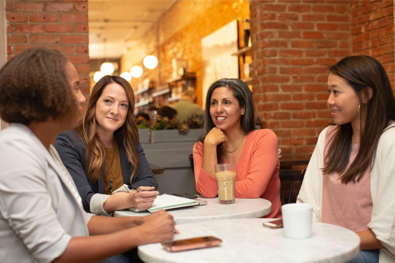 Cuatro mujeres conversando en café